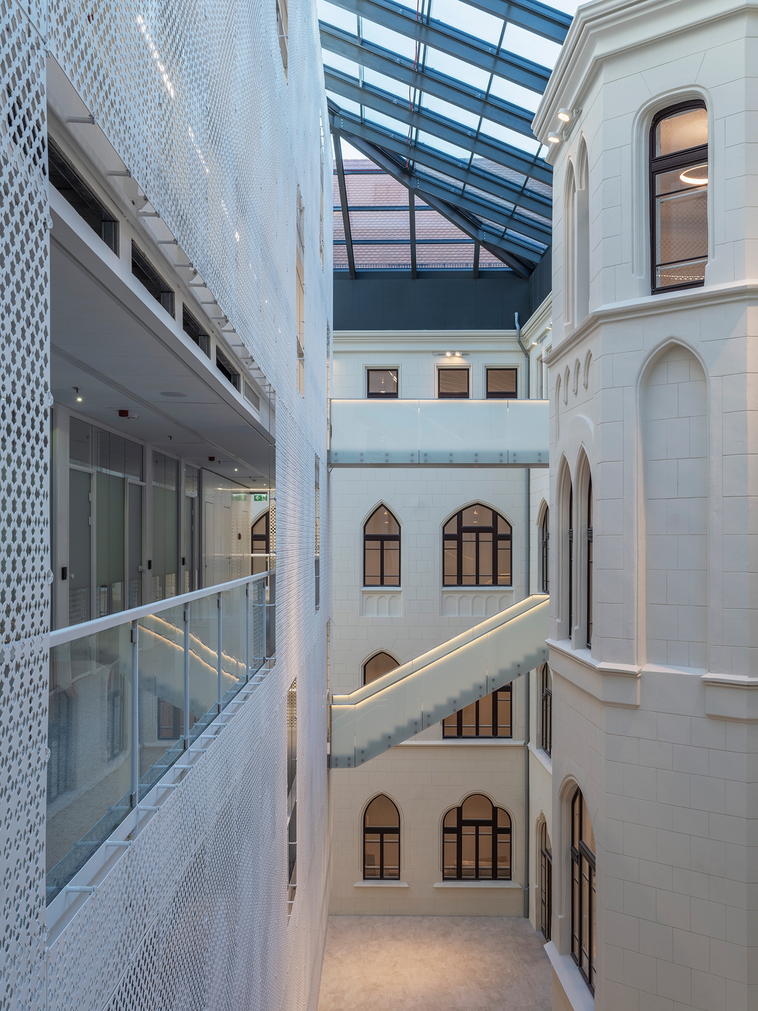 Ez az épületrész demokratizálásra törekszik a Szentháromság tér felé eső, díszesebb főépületrész és az egyszerűbb hátsó szárnyak között, ám mindeközben szerkezetileg csak lépcsőzetes hidakkal, tisztelettel ér hozzá a történeti struktúrákhoz.